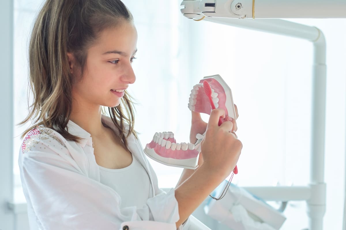 smiling-teenager-girl-in-dental-office-holding-jaw-2022-02-01-01-26-57-utc(1)(1)